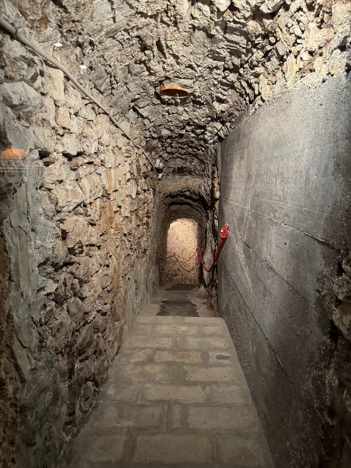 Narrow stone passage beneath the house leading to the 16th-century cold store