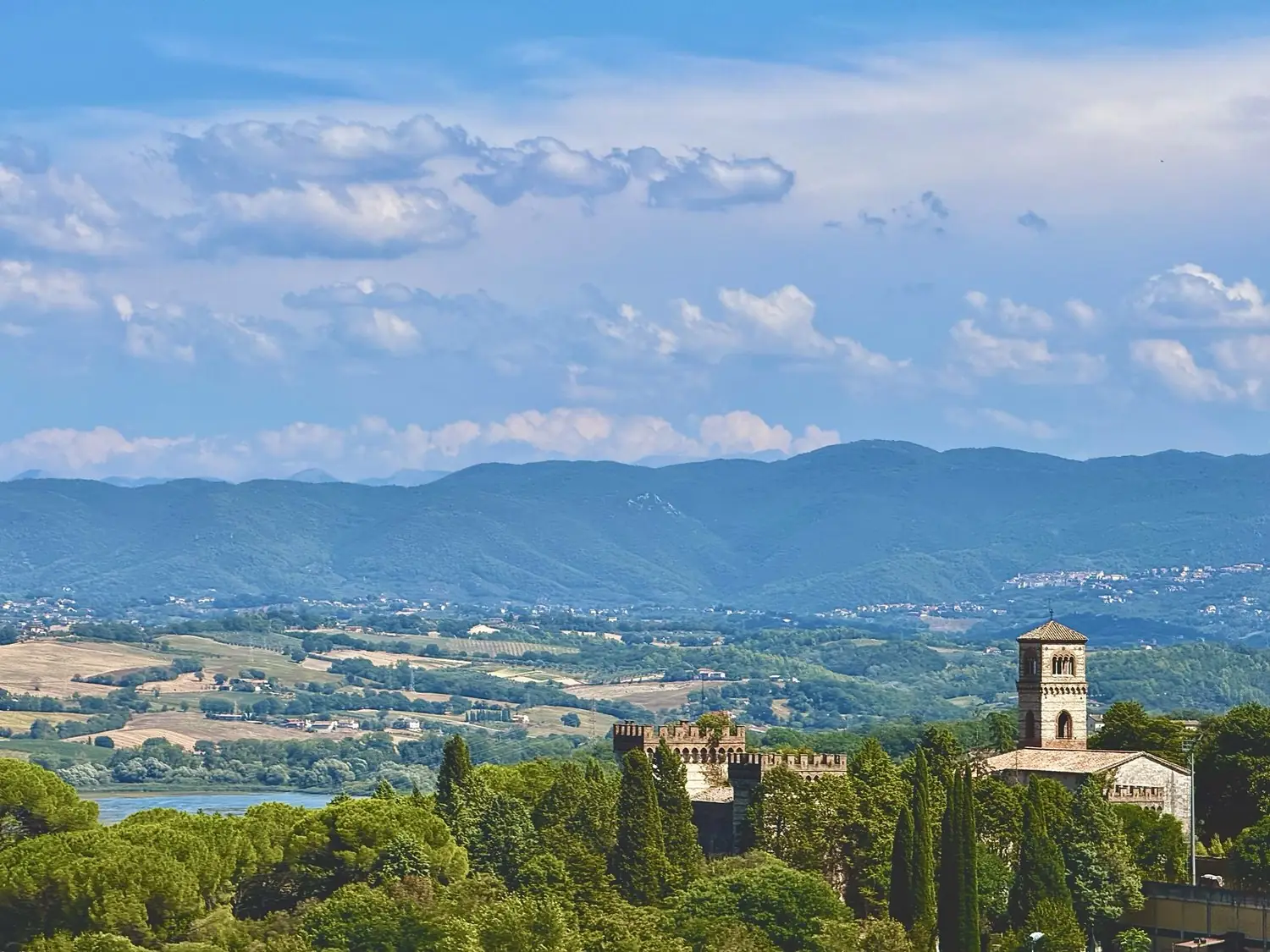 The castle and Romanesque bell tower at Narni above a lake, with hills behind