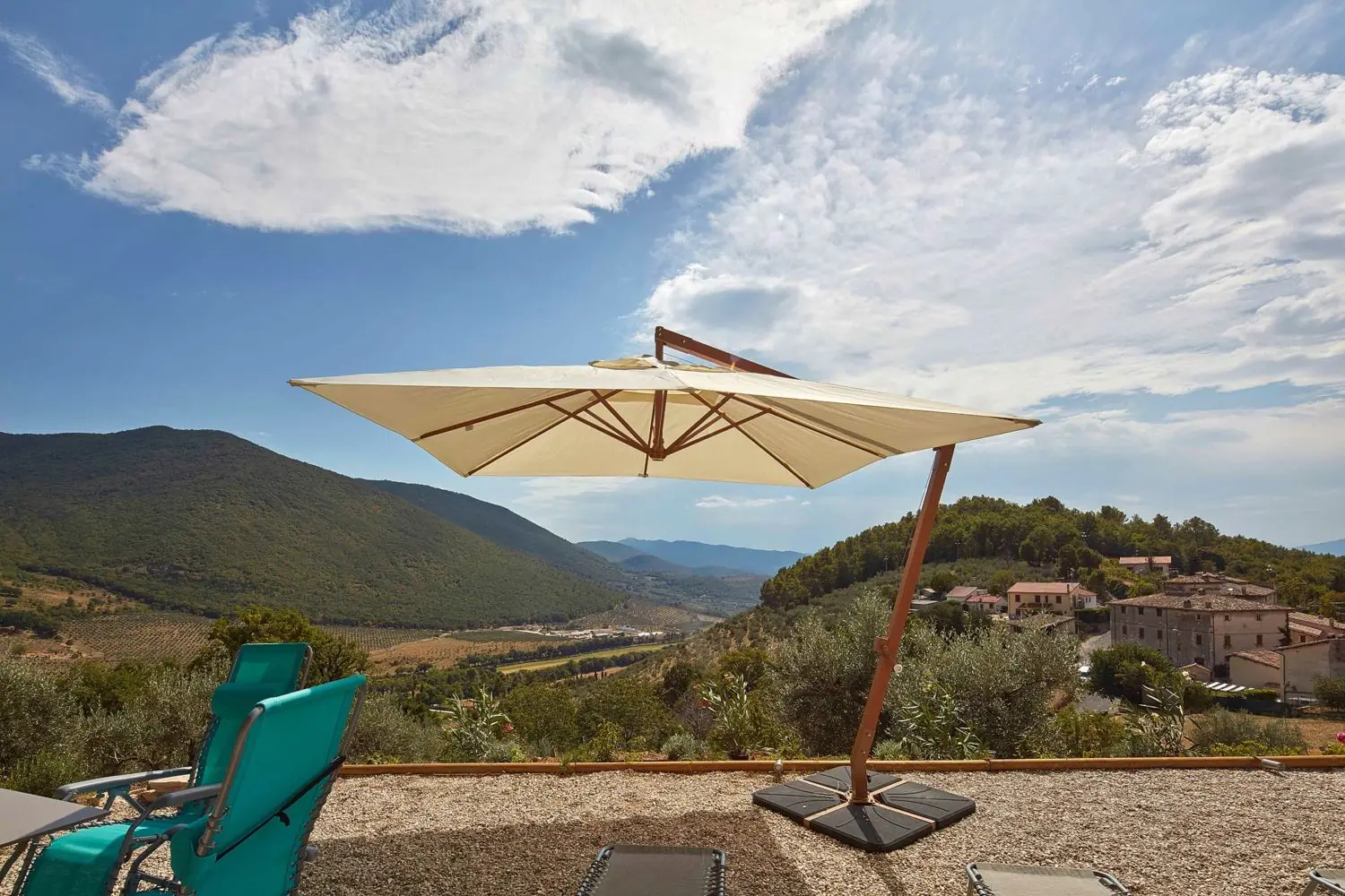 Parasol and reclining chairs facing the valley