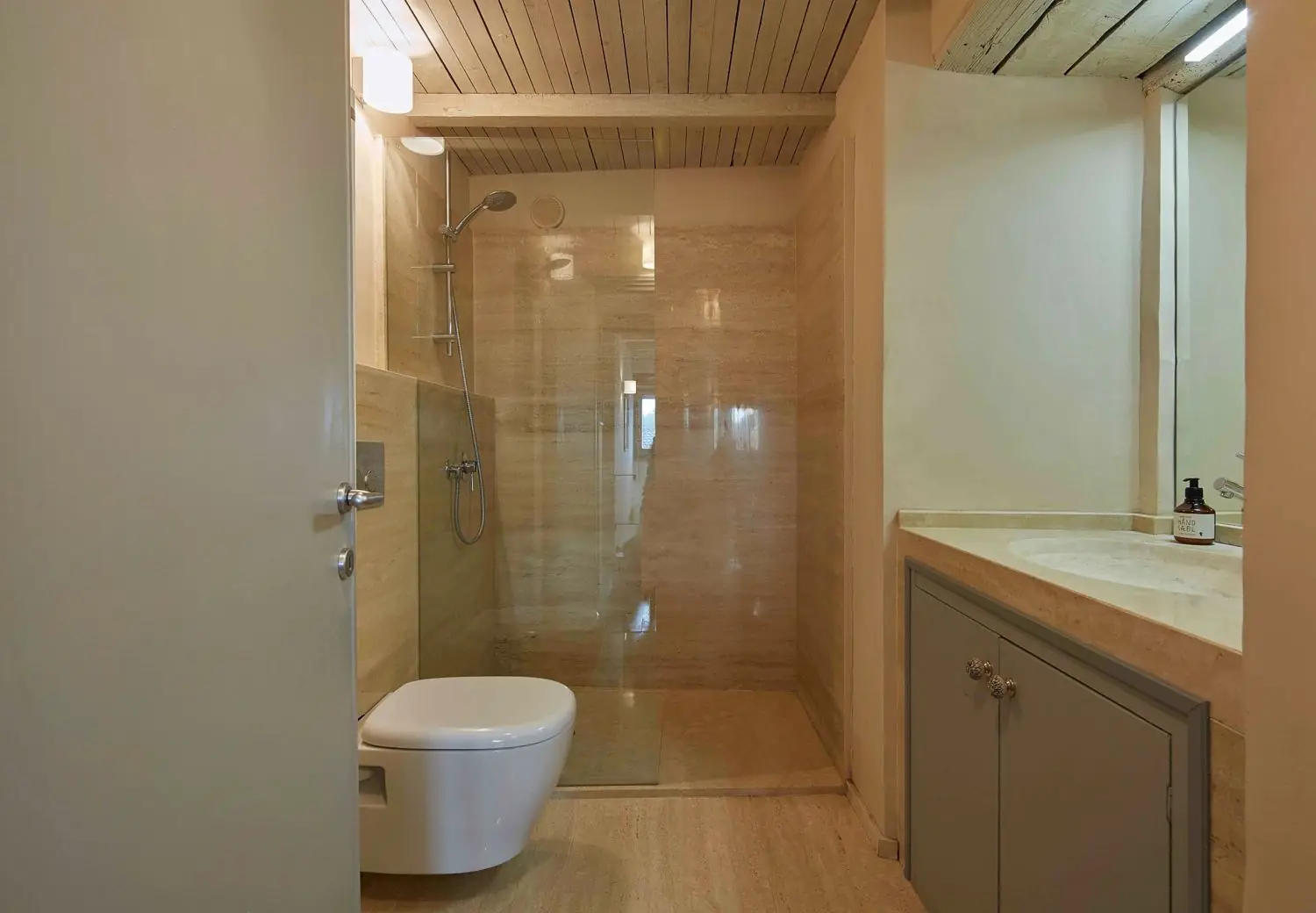 Shower room in travertine with a walk-in shower