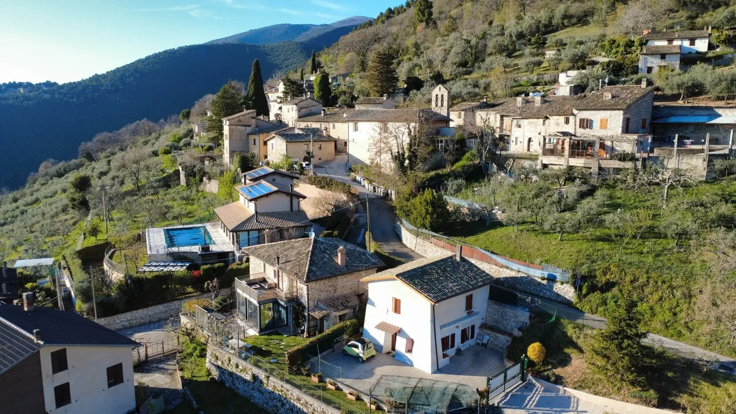 Aerial view of the village of Silvignano on its hillside, with Casa Ventinove below the house with the pool