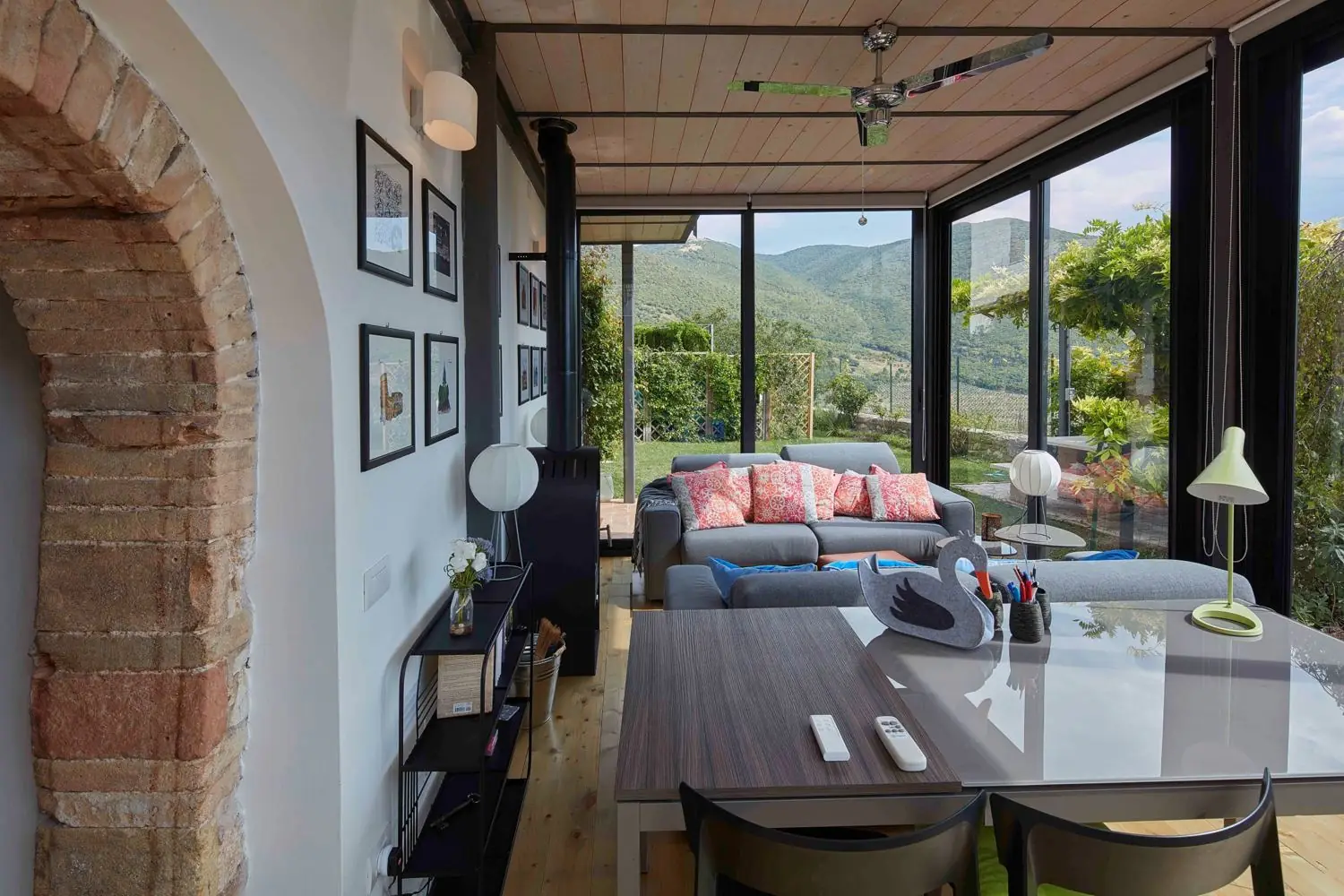 Winter garden with sofas, glass walls and the hills beyond